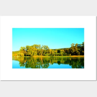 Scene from Lago Cedri in Lapedona with trees bathed in sunlight and the calm waters of the lake reflecting that lushness Posters and Art